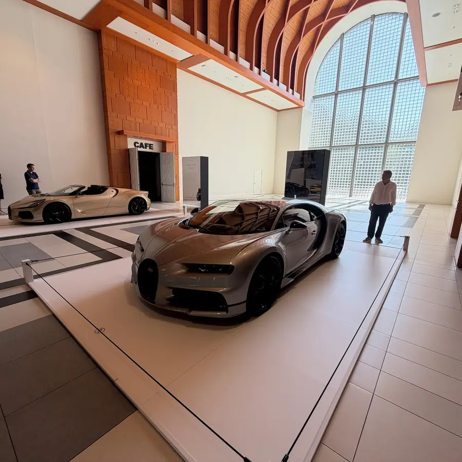 A sports car on a plinth in a bright showroom